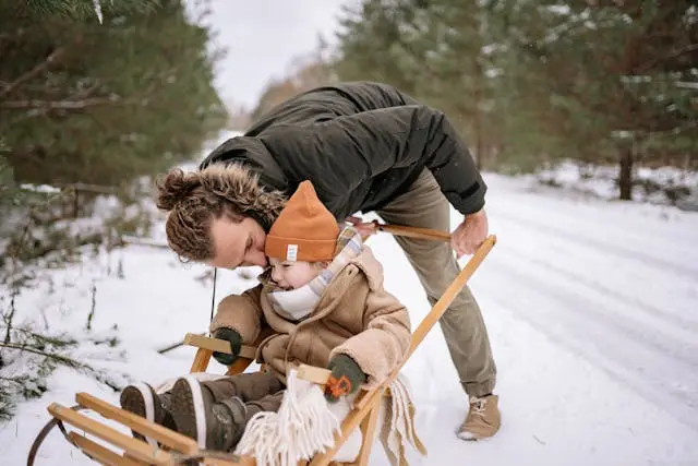 persona con su hijo jugando en invierno