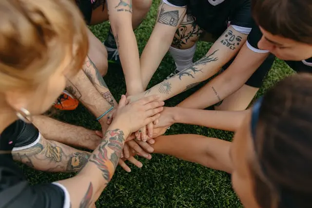 varias manos juntas colaborando en equipo