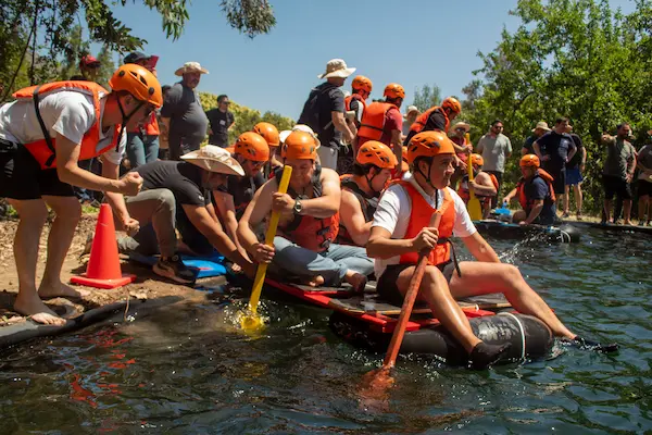 varias personas compietiendo en balsa