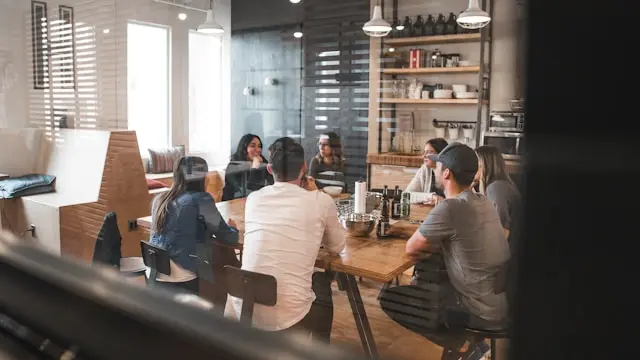 varias personas sentadas compartiendo en una mesa