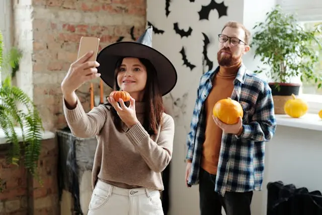 un hombre y una mujer vestidos con sombreros y calabazas