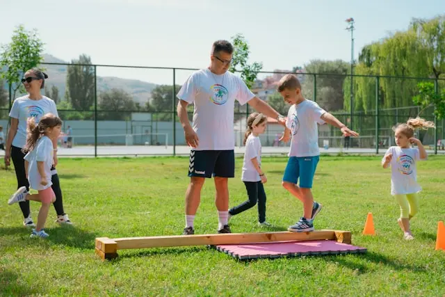 varios niños jugando con sus profesores