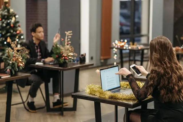 dos personas en oficina con arbol de navidad
